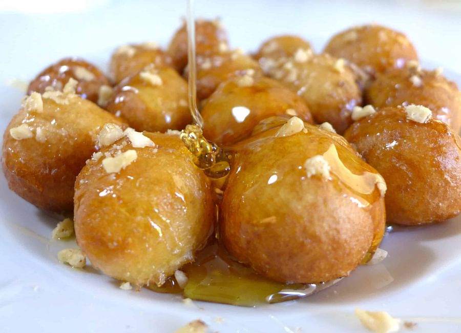 Assortment of lesser known Greek desserts including Loukoumades, Melomakarona, and Kataifi